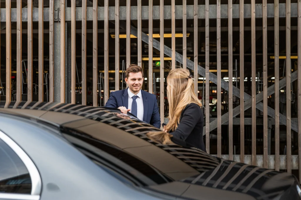 Chauffeur en passagier bij de auto in een parkeergarage