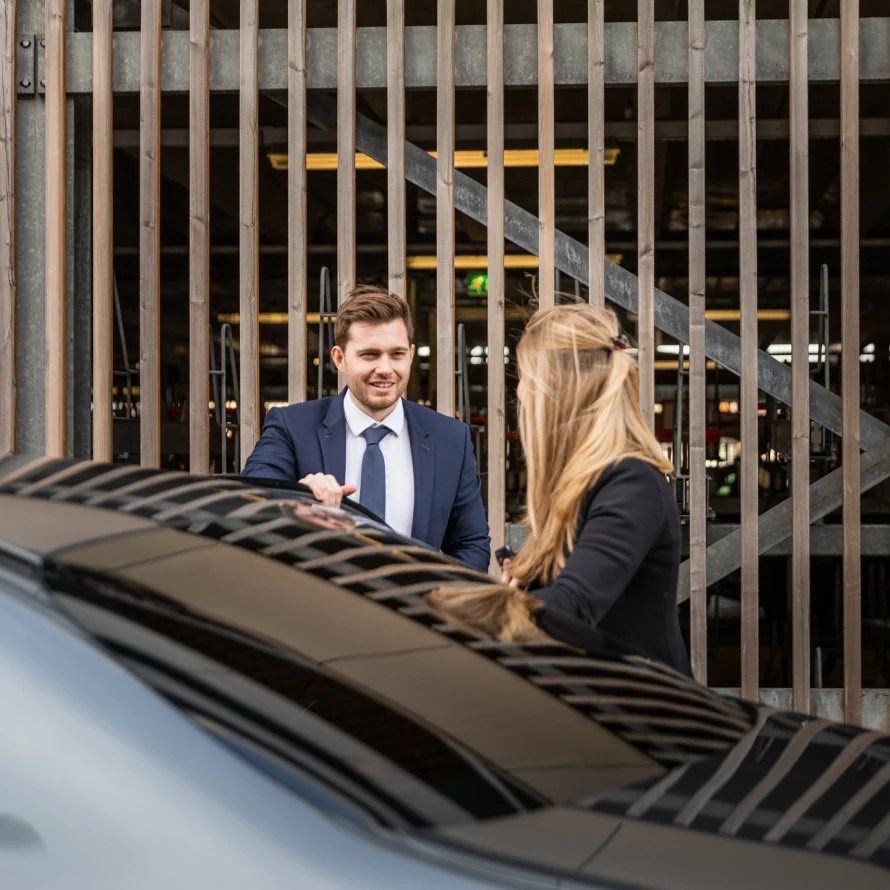 Chauffeur en passagier bij de auto in een parkeergarage