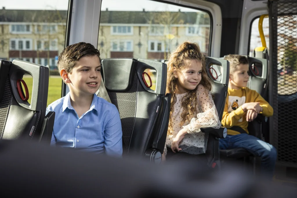 Lachende jongen in de bus van het leerlingenvervoer