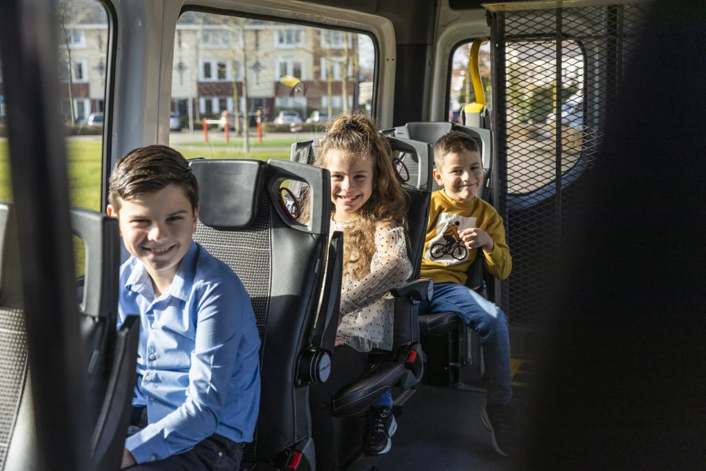 Lachende kinderen in de bus van het leerlingenvervoer