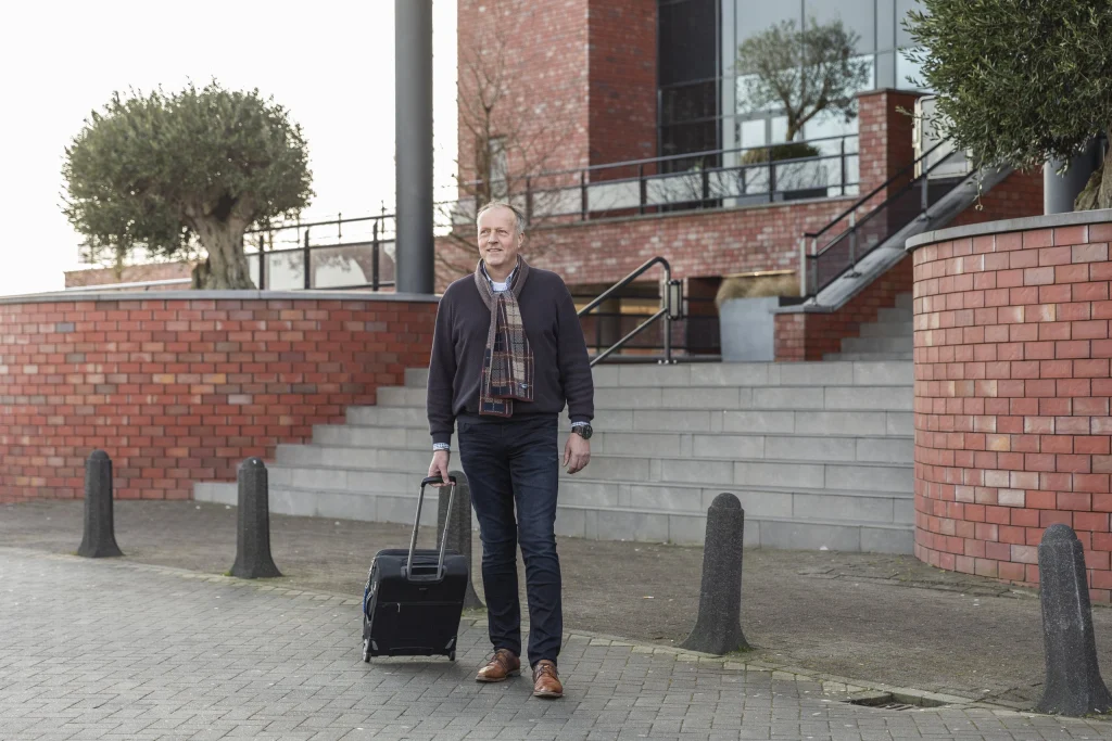 Reiziger met rolkoffer loopt naar de taxi