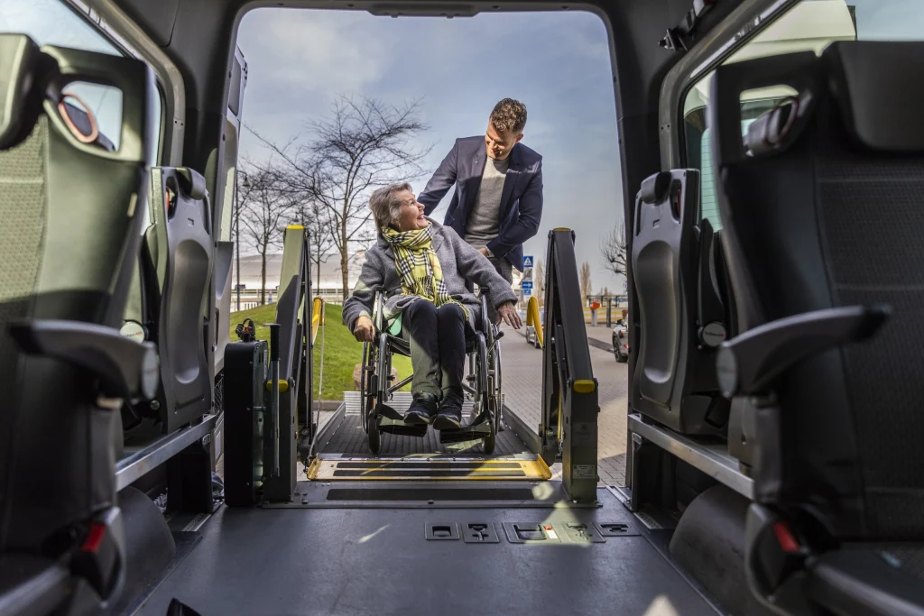 Zicht vanuit de rolstoelbus op een passagier in een rolstoel op de lift