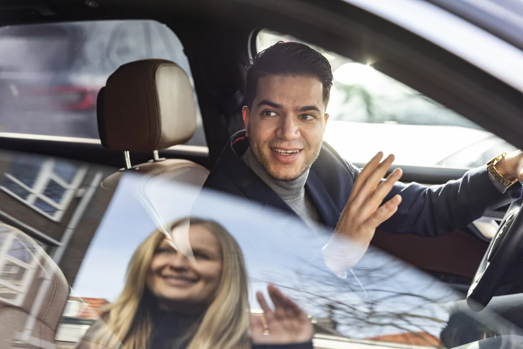 Zwaaiende passagiers in de auto