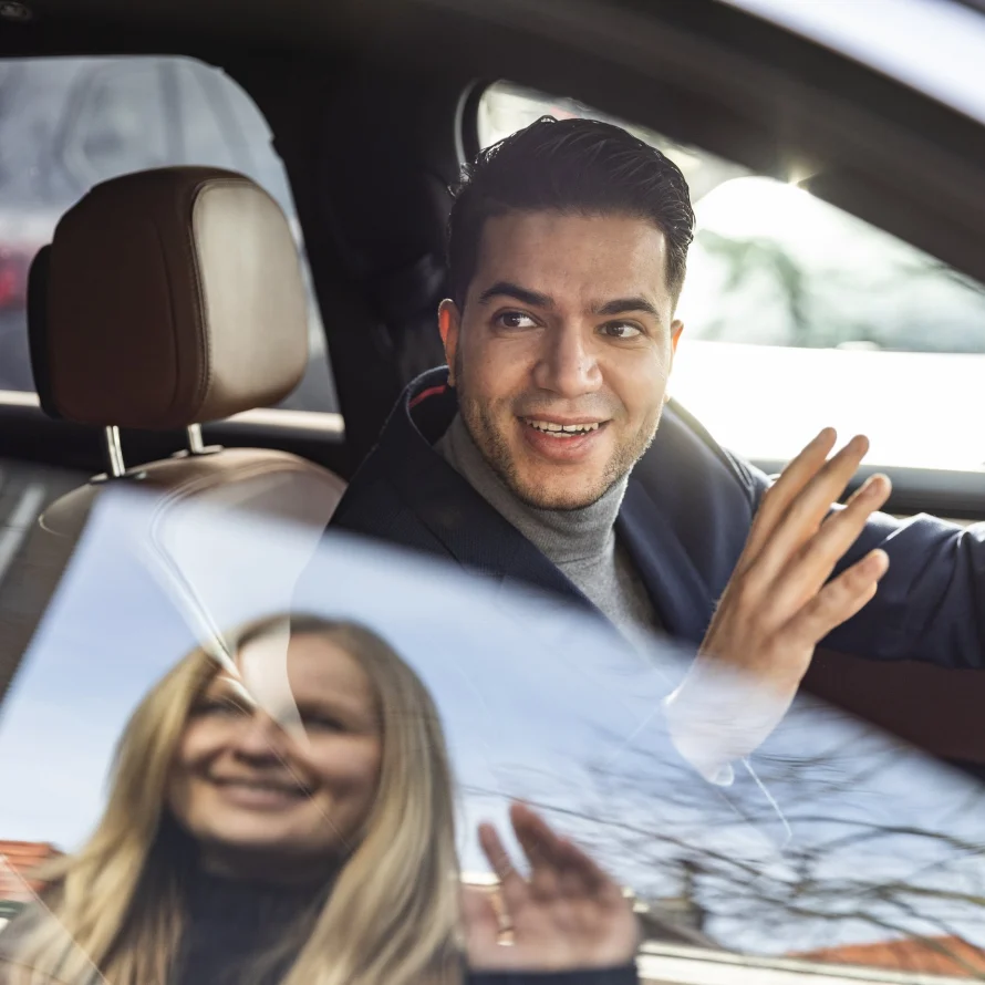 Zwaaiende passagiers in de auto